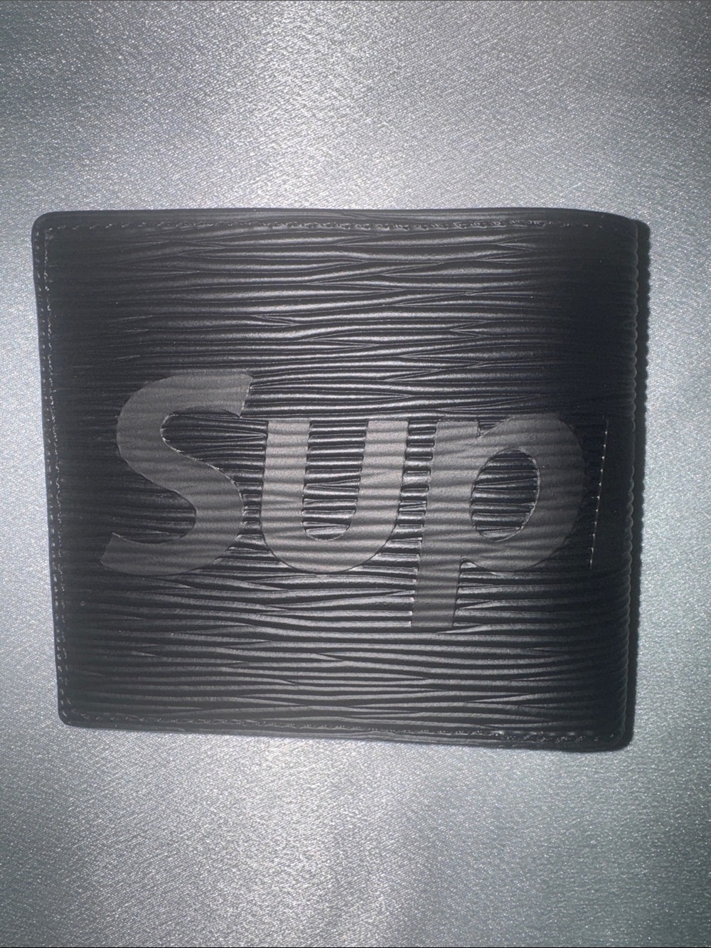 Louis Vuitton x Supreme Epi leather wallet featuring an embossed Supreme logo!